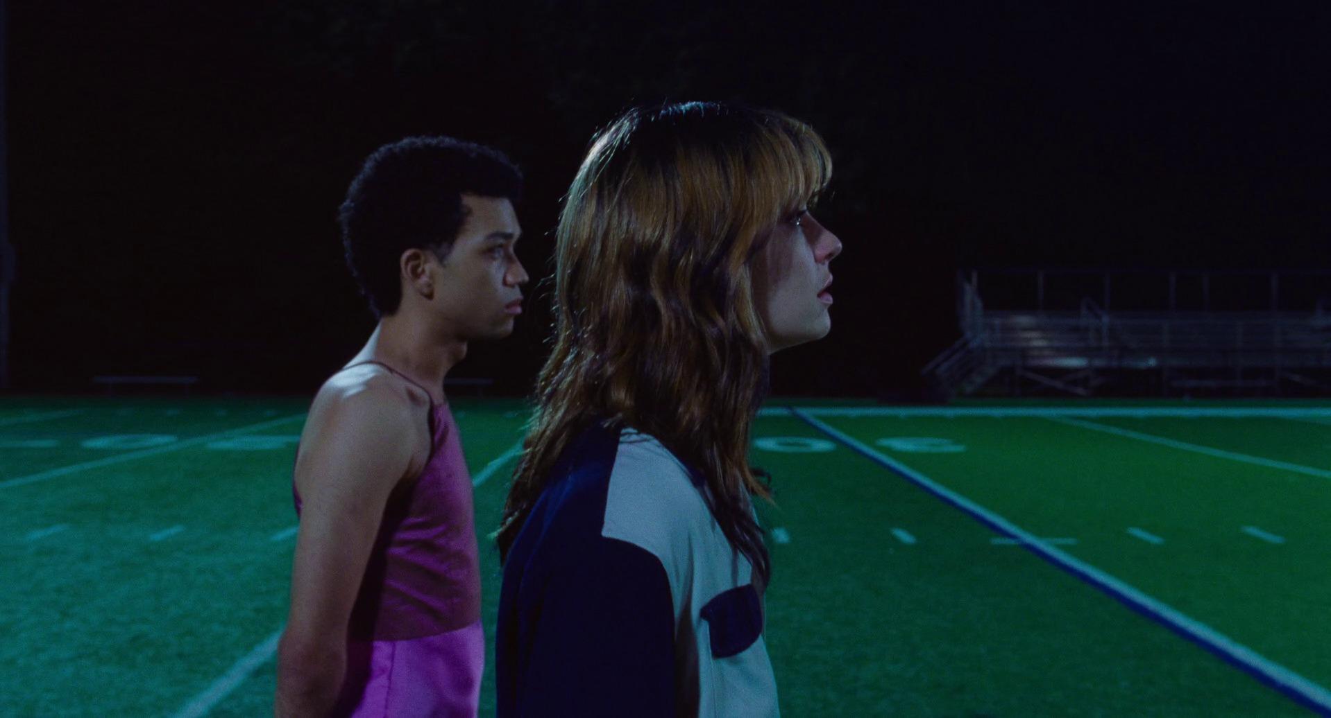 Owen and Maddy walking on a football field